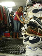 Girl with pile of shoes, photograph Jose Castillo, University of North Texas Libraries collection